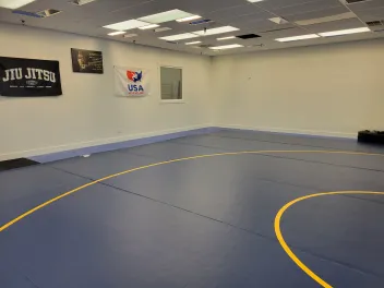 the mat with a USA Wrestling flag on the wall